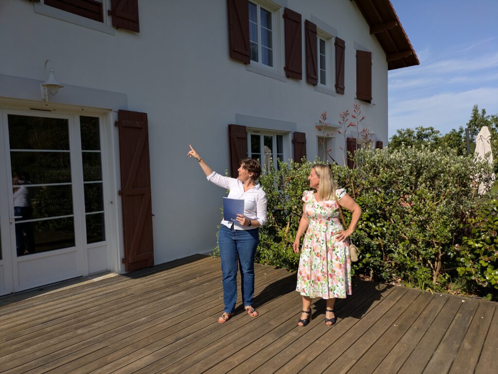 Visite d’estimation d’une maison sur le Bassin d’Arcachon, devant la façade avec la propriétaire